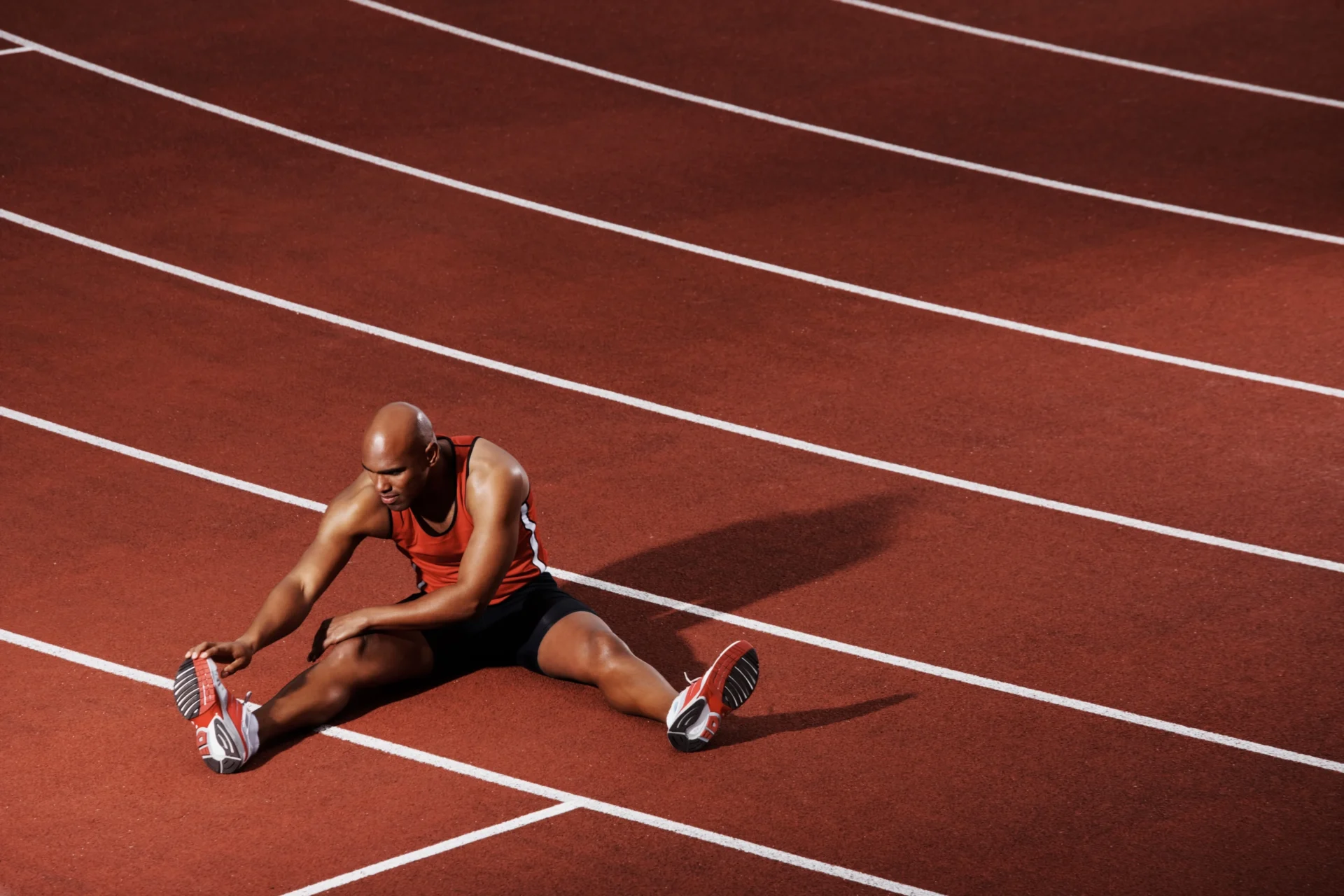 Athlete stretching on running track.